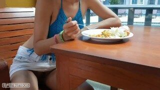 Girl with red hair sits without panties in a public dining room